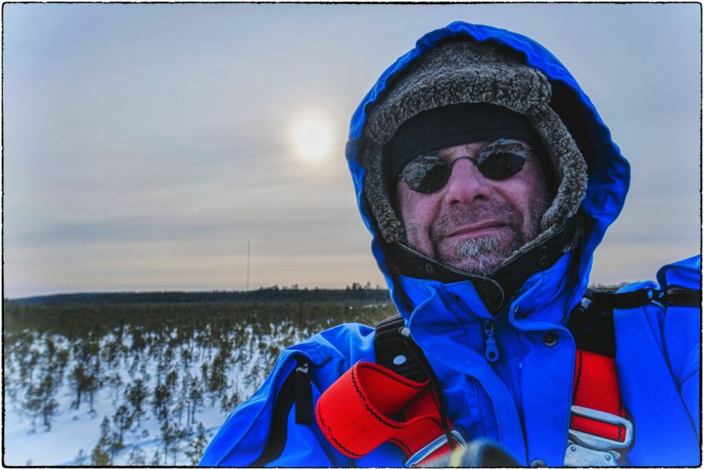 portrait Person in blue workingsuit before sun in grey sky