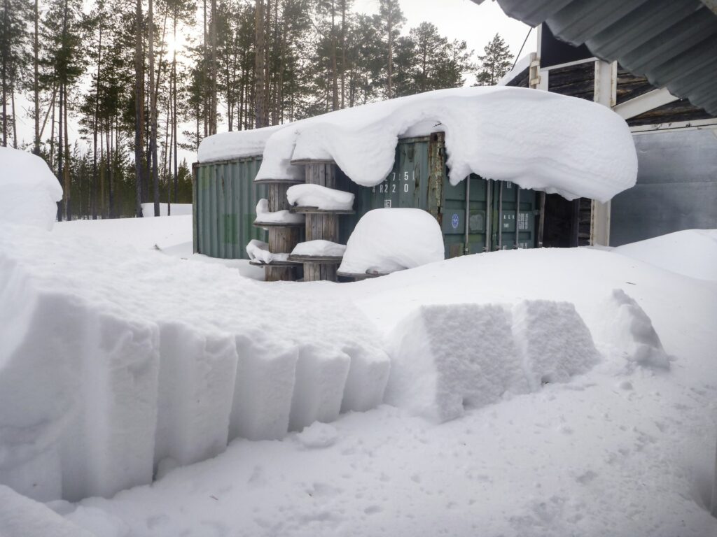 snow covered green container before bunker at Zotto