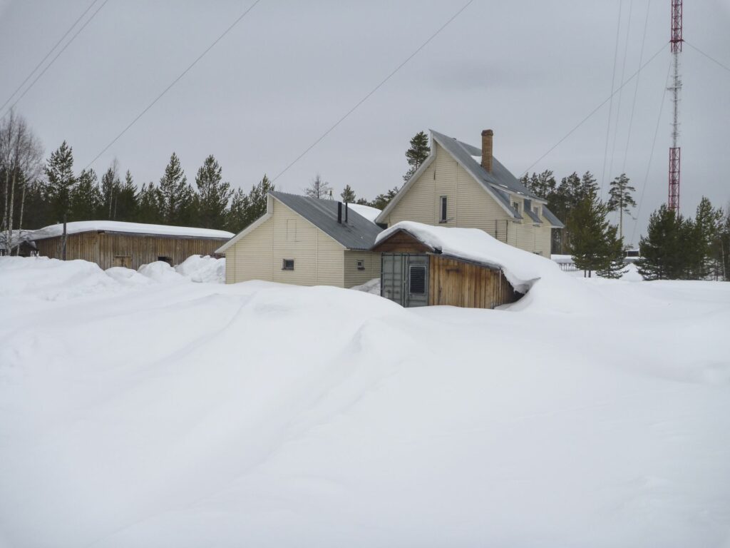 house at Zotto tall towerstation in deep snow before grey sky