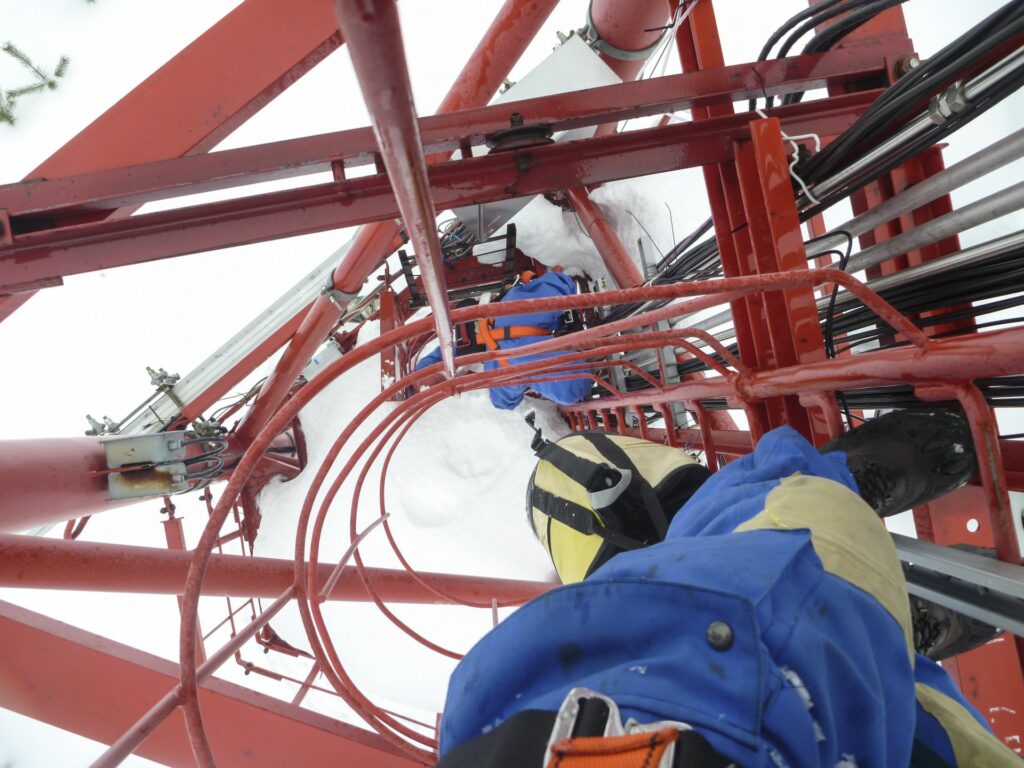 2 persons in blue snowsuits and climbing gear in the ladder shaft of the Tall Tower in freezing cold weather in winter