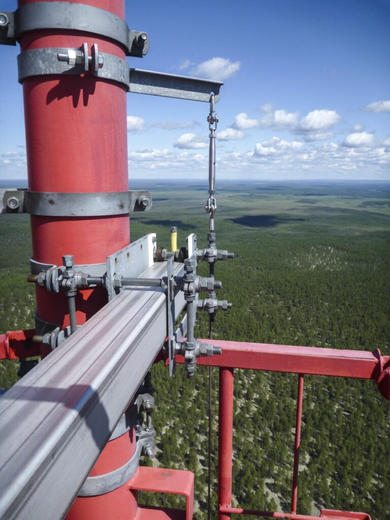 gigantic view into the distance from the top of the Tall tower with blue blue sky white clouds and green trees to the horizon