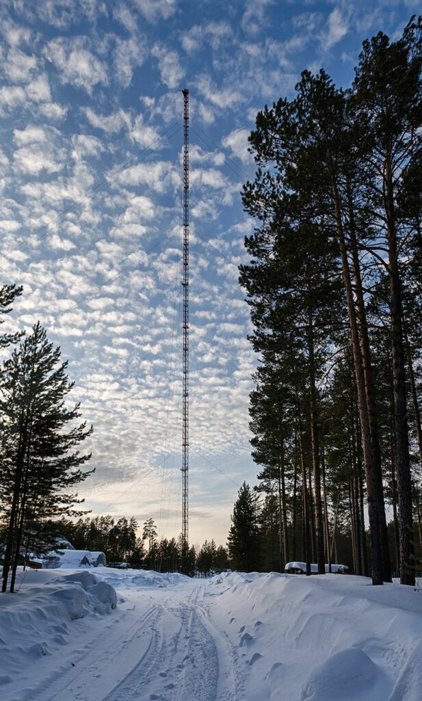 Zotino Tall Towerfrom far awayin winter with nice little clouds before blue sky and deep snow in front