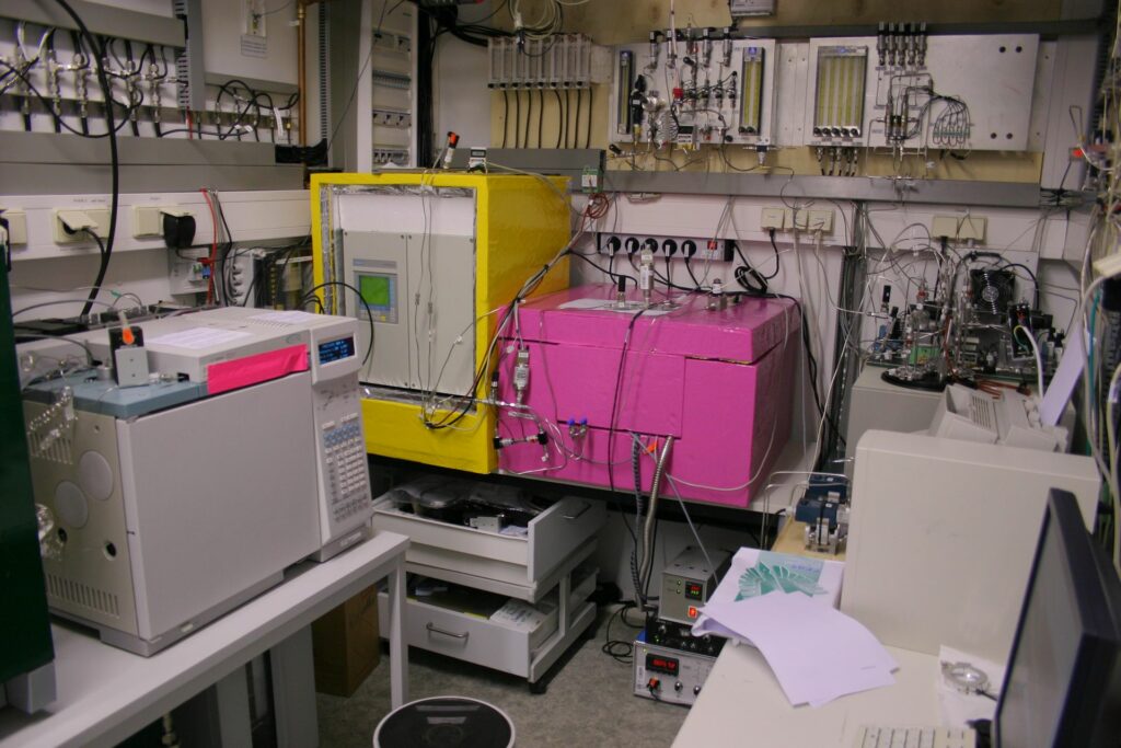 various devices and big pink and yellow boxes in grey laboratory at Zotto station